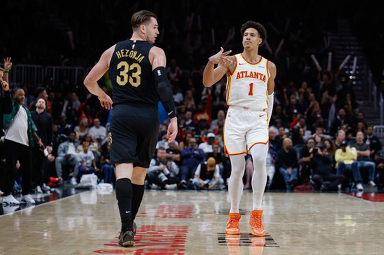 Jalen Johnson, de los Hawks de Atlanta, festeja luego de atinar un triple ante Mario Hezonja, de los Cavaliers de Cleveland, en el duelo del jueves 29 de octubre de 2026 (AP Foto/Erik S. Lesser)
