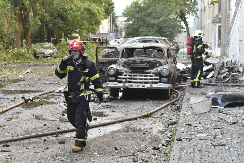 Bomberos en el lugar de un ataque aéreo ruso, el sábado 12 de julio de 2025, en Leópolis, Ucrania. (AP Foto/Mykola Tys)