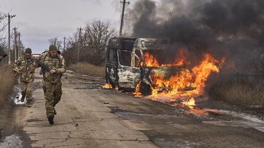 En esta foto distribuida por la 10ma Brigada de Montaña Edelweiss, de Ucrania, soldados ucranianos pasan junto a un bus impactado por un dron ruso cerca de Bajmut, región de Donetsk, Ucrania, 23 de noviembre de 2023. (Shandyba Mykyta, 10ma Brigada de Montaña Edelweiss, via AP)