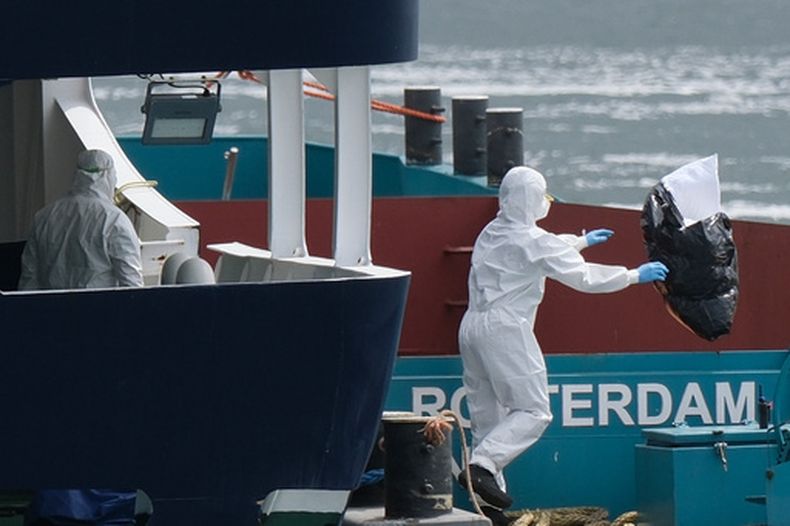 Operarios vestidos con equipos de protección retiran la basura del crucero MV Hondius a su llegada al puerto de Rotterdam, Holanda, el 18 de mayo de 2026. (AP Foto/Patrick Post)