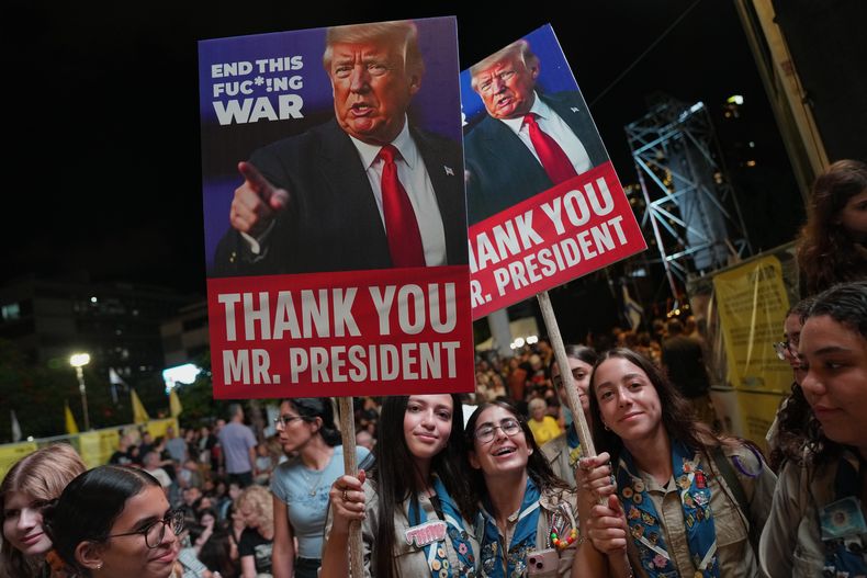 Con carteles que muestran la imagen del presidente estadounidense Donald Trump, un grupo de personas participa en una marcha de apoyo a los rehenes secuestrados por Hamás, en un sitio conocido como la plaza de los rehenes, en Tel Aviv, Israel, el sábado 11 de octubre de 2025, antes de la liberación prevista de los rehenes retenidos en la Franja de Gaza. (AP Foto/Francisco Seco)