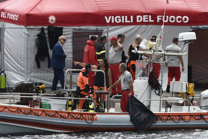 Bomberos y buzos italianos atracan en el puerto de Porticello, en el sur de Italia, el martes 20 de agosto de 2024, mientras los equipos de rescate regresan al lugar donde se hundió un superyate a causa de una tormenta para buscar a seis personas, entre ellas el magnate informático británico Mike Lynch, que se cree que siguen atrapadas en el casco a 50 metros bajo el agua. (AP Foto/Salvatore Cavalli)