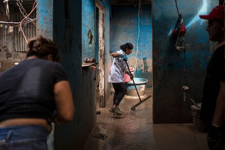 Personas limpian la casa de la familia Olvera Gómez en Poza Rica, en el estado de Veracruz, México, el lunes 13 de octubre de 2025, tras lluvias torrenciales. (AP Foto/Félix Márquez)