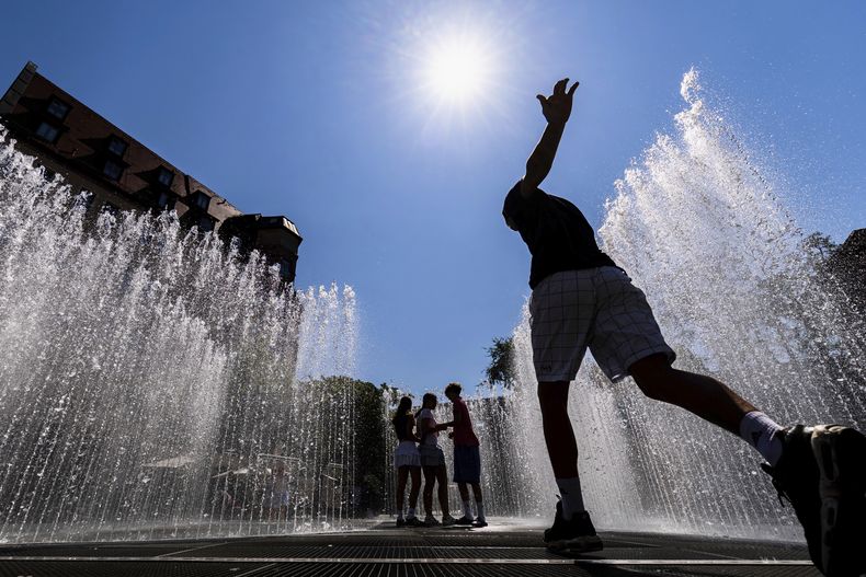 Jóvenes caminan por la instalación de agua Pabellón hexagonal de agua del artista danés Jeppe Hein ante el Neues Museum de Nuremberg, Alemania, el miércoles 2 de julio de 2025. (Daniel Karmann/dpa via AP)