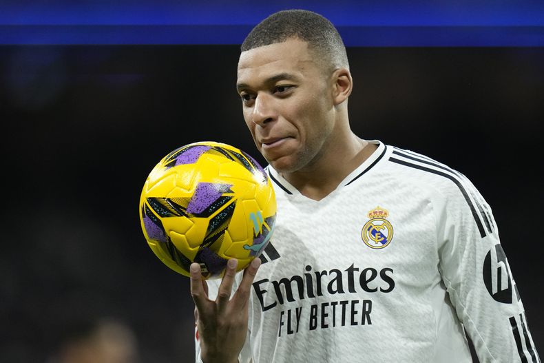Kylian Mbappé del Real Madrid sostiene el balón en el partido contra Las Palmas en la Liga española, el domingo 19 de enero de 2025. (AP Foto/Bernat Armangue)