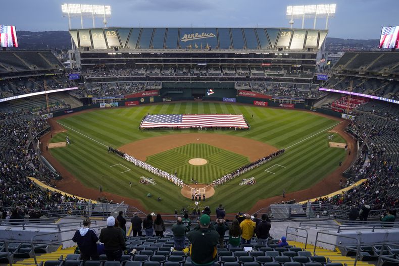 En un parque con pocos espectadores, los Atléticos de Oakland y los Guardianes de Cleveland escuchan el himno nacional antes del juego del jueves 28 de marzo de 2024 (AP Foto/Godofredo A. Vásquez)