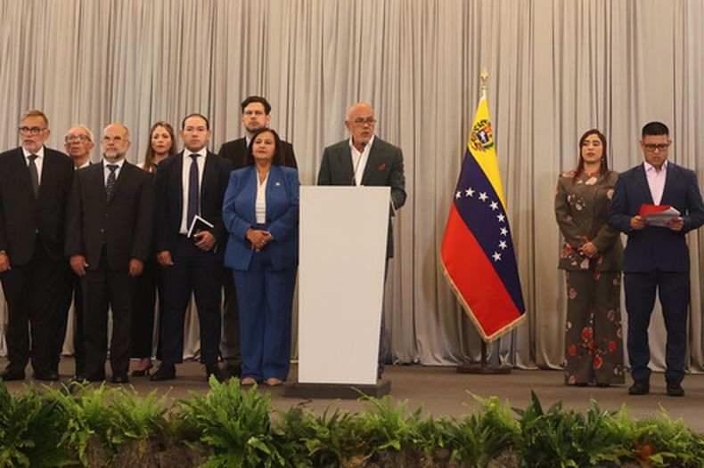 El presidente de la Asamblea Nacional de Venezuela, Jorge Rodríguez, al centro, habla con la líder opositora Dinorah Figuera, al centro izquierda, y su delegación al concluir la tercera ronda de negociaciones políticas, el miércoles 21 de octubre de 2026, en Caracas. (AP Foto/Pedro Mattey)