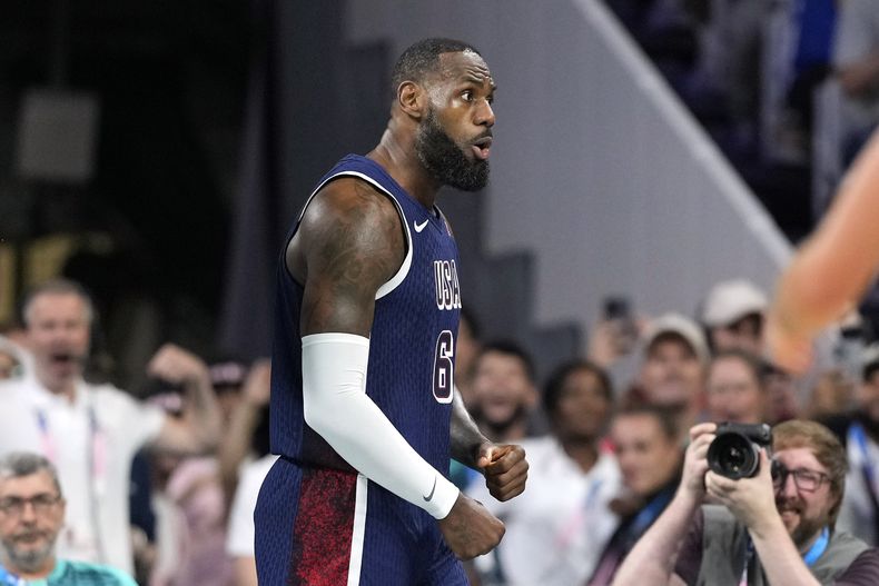 El estadounidense LeBron James celebra tras una volcada en el partido contra Serbia por el torneo de baloncesto de los Juegos Olímpicos de París, el domingo 28 de julio de 2024, en Villeneuve-dAscq, Francia. (AP Foto/Michael Conroy)