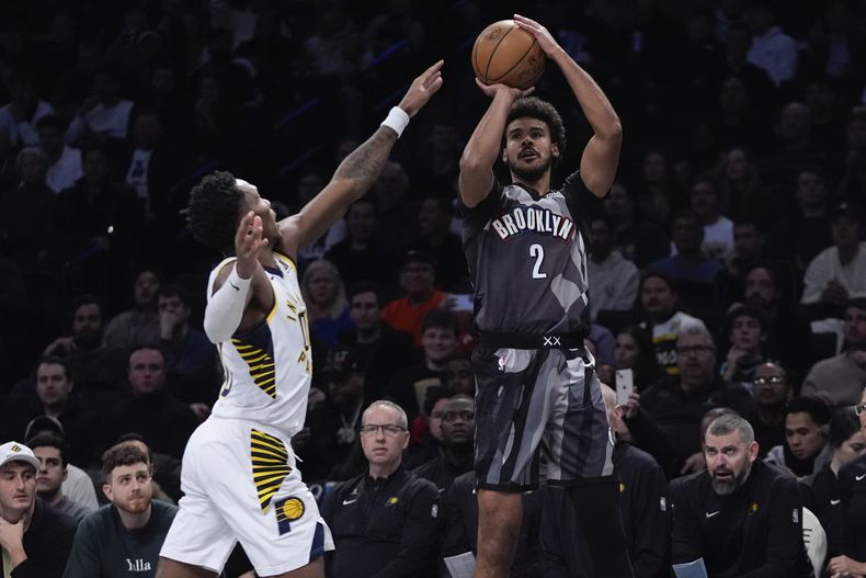 Cameron Johnson (2), de los Nets de Brooklyn, tira ante la presión defensiva de Bennedict Mathurin, de los Pacers de Indiana, durante la primera mitad del juego de baloncesto de la NBA, el miércoles 4 de diciembre de 2024, en Nueva York. (AP Foto/Frank Franklin II)