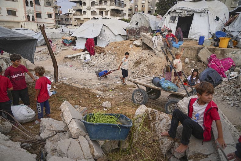 Niños palestinos en un campamento en medio de las ruinas en Ciudad Gaza el 23 de junio del 2025. (AP foto/Jehad Alshrafi)