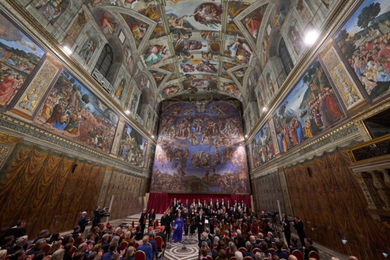 El director de orquesta Harry Christopher, en el centro, junto con el tenor Matthew McKinney, a la izquierda, la soprano Elizabeth Watts, segunda desde la izquierda, y el coro The Sixteen presentan Angels Unawares de James MacMillan en la Capilla Sixtina del Vaticano, el domingo 22 de marzo de 2026. (Foto AP/Domenico Stinellis)