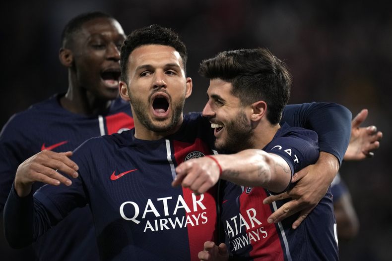 El brasileño del PSG Lucas Beraldo (izquierda) celebra junto al delantero Gonçalo Ramos luego de anotar el segundo gol de su equipo durante el partido de la Liga de Francia ante el Lyon en el Parque de los Príncipes, en París, el domingo 21 de abril de 2024. (AP Foto/Christophe Ena)