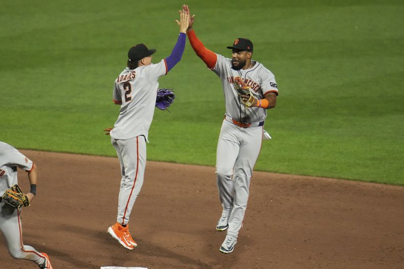 Los dominicanos Willy Adames (2) y Jerar Encarnación, de los Gigantes de San Francisco, festejan la victoria sobre los Piratas de Pittsburgh, el martes 5 de agosto de 2025 (AP Foto/Gene J. Puskar)