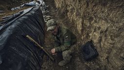 Un soldado ucraniano se sienta en una trinchera en el frente cerca de Bájmut, en la región de Donetsk, Ucrania, el lunes 22 de mayo de 2023. (AP Foto/Libkos)