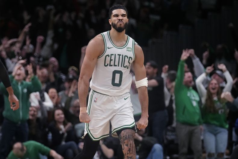 Jayson Tatum (0), alero de los Celtics de Boston, celebra después de conseguir un triple durante el tiempo extra del juego de baloncesto de la NBA en contra de los Timberwolves de Minnesota, el miércoles 10 de enero de 2024, en Boston. Tatum anotó 45 puntos en la victoria de los Celticos por 127-120. (AP Foto/Charles Krupa)