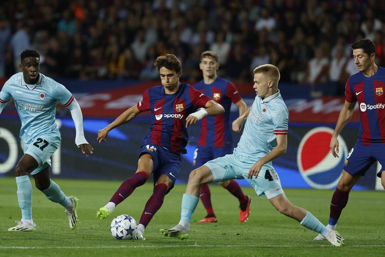 Joao Félix (segundo a la izquierda) del Barcelona avanza con el balón frente a Arthur Vermeeren del Amberes en el partido de la Liga de Campeones, el martes 19 de septiembre de 2023, en Barcelona. (AP Foto/Joan Monfort)