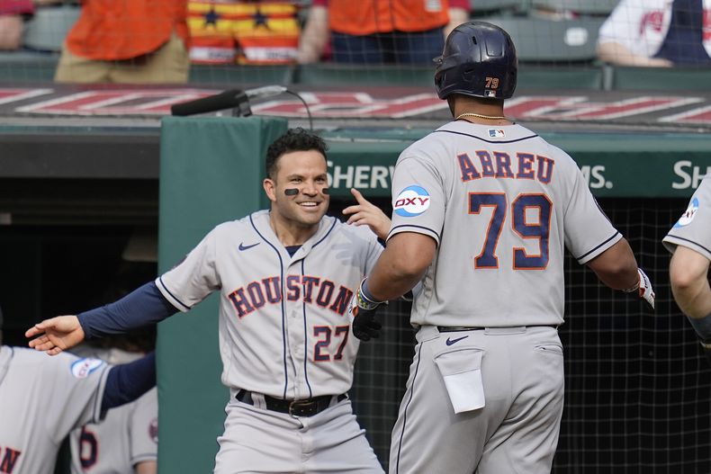 El venezolano José Altuve, de los Astros de Houston, felicita al cubano José Abreu, quien babeó un jonrón en el primer inning del duelo del sábado 10 de junio de 2023, ante los Guardianes de Cleveland (AP Foto/Sue Ogrocki)