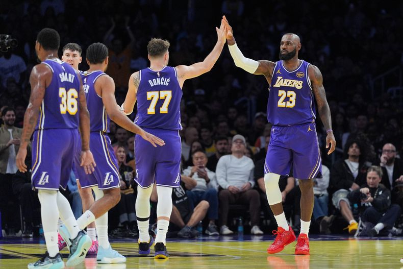 LeBron James, de los Lakers de Los Ángeles, festeja con su compañero Luka Doncic, en el encuentro del martes 25 de noviembre de 2025 ante los Clippers de la misma ciudad (AP Foto/Jae C. Hong)