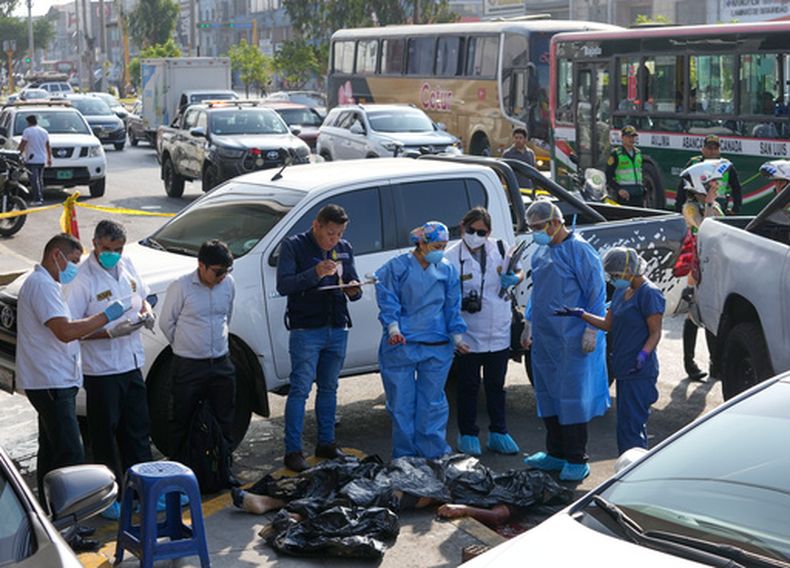ARCHIVO - Investigadores de la Unidad Criminalística rodean el cuerpo del conductor de transporte colectivo Diego Ticona, quien según la policía fue baleado por dos personas en una motocicleta, en el barrio La Victoria de Lima, Perú, el 21 de enero de 2026. (AP Foto/Martín Mejía, Archivo)