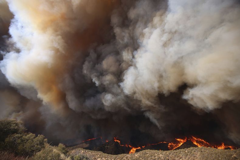 Columnas de humo se alzan mientras el incendio Hughes arde en Castaic, California, el miércoles 22 de enero de 2025. (AP Foto/Ethan Swope)