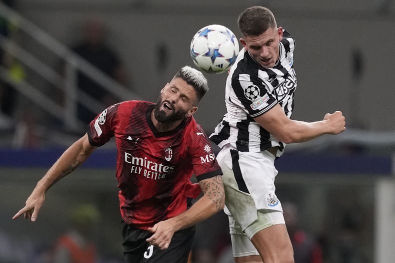 Olivier Giroud (izquierda) del AC Milan pugna el balón con Sven Botman de Newcastle durante el partido de la Liga de Campeones, el martes 19 de septiembre de 2023, en Milán. (AP Foto/Antonio Calanni)