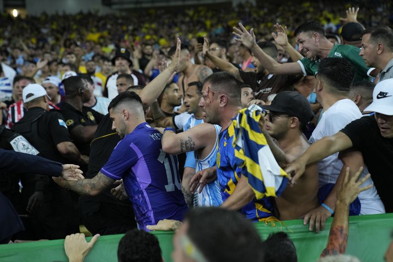 En foto del martes 21 de noviembre del 2023, aficionados de Brasil y Argentina pelean durante el encuentro de la eliminatoria sudamericana a la Copa Mundial 2026. (AP Foto/Silvia Izquierdo)