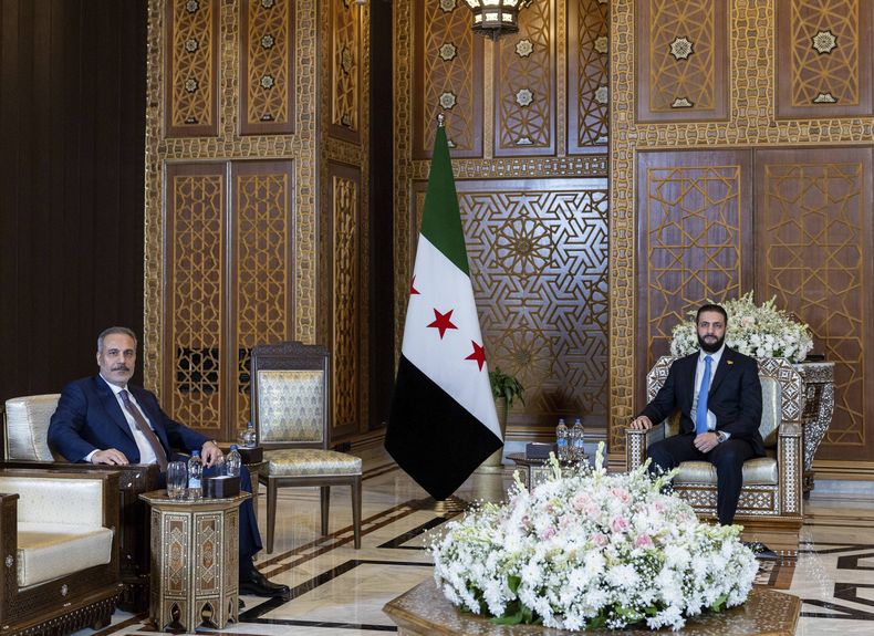 Foto suministrada por el Departamento de Prensa del Ministerio de Relaciones Exteriores de Turquía que muestra al ministro de exteriores turco Hakan Fidan (izq) con el presidente interino sirio Ahmad Al-Sharaa en Damasco el 7 de agosto del 2025. (Departamento de Prensa del Ministerio de Relaciones Exteriores de Turquía via AP)