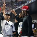 Luis Arráez (centro) de los Marlins de Miami es felicitado tras anotar mediante un jonrón de Jesús Sánchez en el juego ante los Cardenales de San Luis, el martes 4 de julio de 2023, en Miami. (AP Foto/Lynne Sladky)
