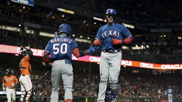 Mitch Garver, derecha, de los Rangers de Texas, celebra con Juan Pablo Martínez (50) después de batear un cuadrangular solitario en contra de los Gigantes de San Francisco durante la sexta entrada del juego de béisbol, el viernes 11 de agosto de 2023, en San Francisco. (AP Foto/Godofredo A. Vásquez)