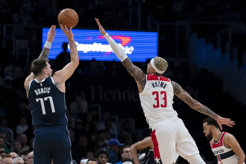 El esloveno Luka Doncic, de los Mavericks de Dallas, dispara frente a Kyle Kuzma, de los Wizards de Washington, en el encuentro del miércoles 15 de noviembre de 2023 (AP Foto/Stephanie Scarbrough)