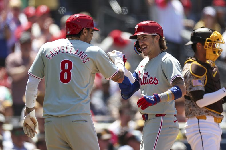 Bryson Stott celebra su jonrón de dos carreras con su compañero de los Filis de Filadelfia Nick Castellanos en la cuarta entrada del juego ante los Padres de San Diego el domingo 28 de abril del 2024. (AP Foto/Brandon Sloter)