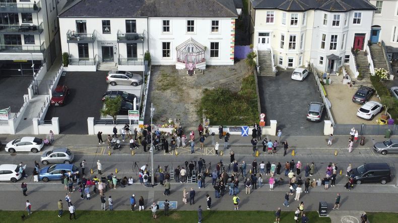 Fans reunidos fuera de la antigua casa de Sinéad OConnor previo al funeral de la cantante en Bray, en el condado de Wicklow, Irlanda, el martes 8 de agosto de 2023. (Niall Carson/PA vía AP)