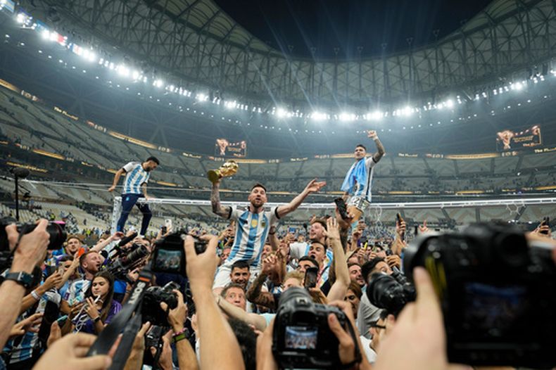 FILE - El capitán de Argentina, Lionel Messi, celebra con el trofeo entre fanáticos tras ganar la final de la Copa del Mundo ante Francia en Lusail, Qatar, Dic. 18, 2022. (AP Foto/Martin Meissner, File)
