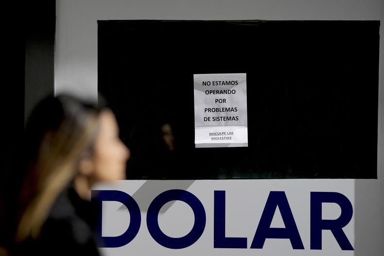 Un cartel anuncia problemas operativos en un local de cambio de moneda en Buenos Aires, Argentina, el lunes 14 de agosto de 2023. El peso argentino se hundió el lunes después de que el candidato ultraderechista resultara el más votado en las elecciones primarias en las que se eligen los candidatos a presidente. (AP Foto/Natacha Pisarenko)