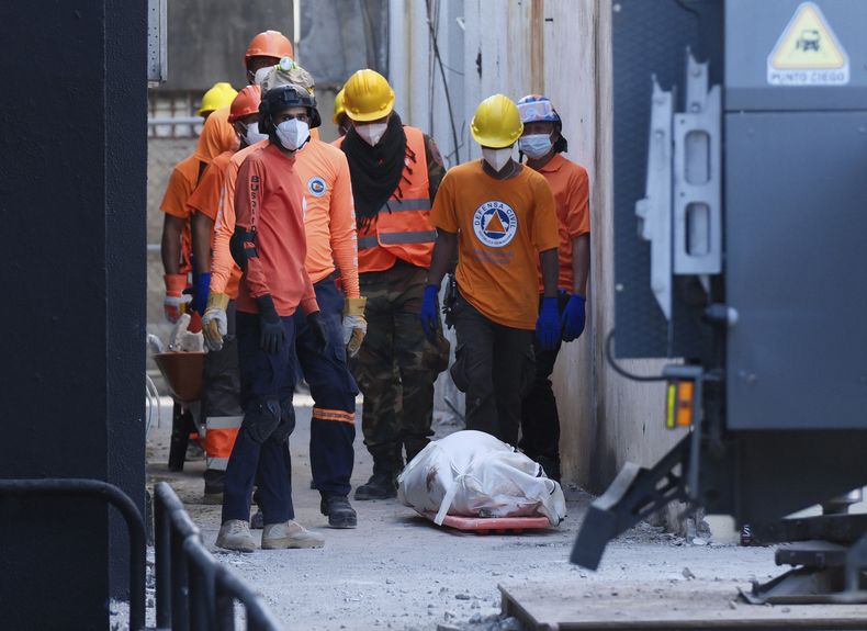 Rescatistas, junto al cadáver recuperado de una persona que falleció por el derrumbe del techo de la discoteca Jet Set durante un concierto de merengue dos noches antes, en Santo Domingo, República Dominicana, el 9 de abril de 2025, (AP Foto/Ricardo Hernández)