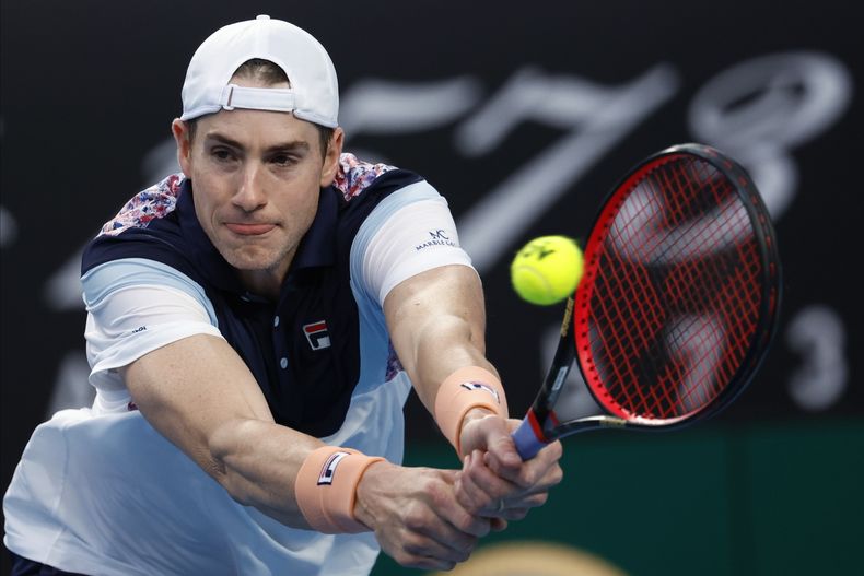 ARCHIVO - El estadounidense John Isner realiza una devolución al francés Adrian Mannarino en el Abierto de Australia, el 18 de enero de 2023 (AP Foto/Asanka Brendon Ratnayake)