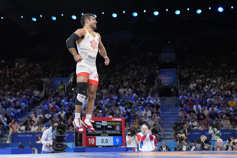 El puertorriqueño Sebastián Rivera celebra tras vencer al mongol Tumur Ochir Tulga en la categoría de 65 kilogramos de la lucha libre de los Juegos Olímpicos de París, el domingo 11 de agosto de 2024. (AP Foto/Eugene Hoshiko)