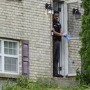 Un miembro del Departamento de Policía de Florence, Kentucky, frente a la puerta de una casa que fue escenario de un tiroteo, el sábado 6 de julio de 2024, en Florence, Kentucky. (AP Foto/Carolyn Kaster)
