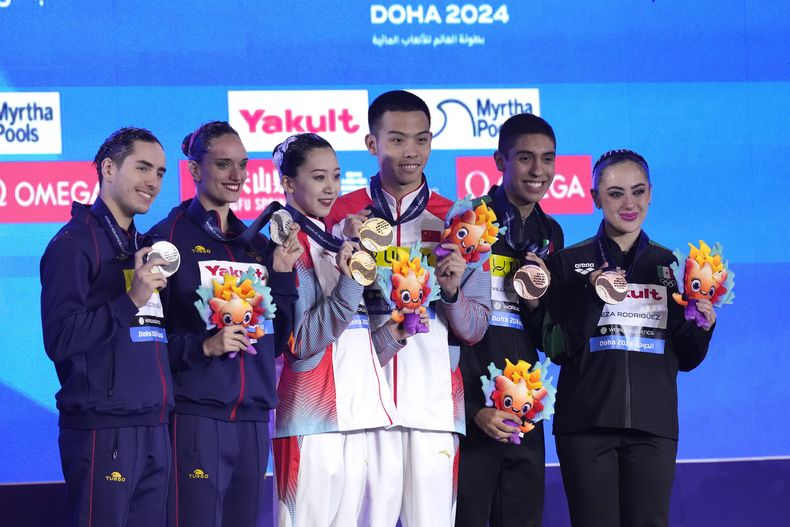 Ls medallistas de oro Shi Haoyu y Cheng Wentao de China, al centro, junto a los españoles Dennis Gonzalez Boneu y Mireia Hernandez Luna que ganaron la plata y los mexicanos Trinidad Meza Rodriguez y Diego Villalobos Carrillo, que fueron plata posan en el podio tras la competencia en el Campeonato Mundial de Natación en Doha, Qatar el sábado 10 de febrero del 2024. (AP Foto/Lee Jin-man)