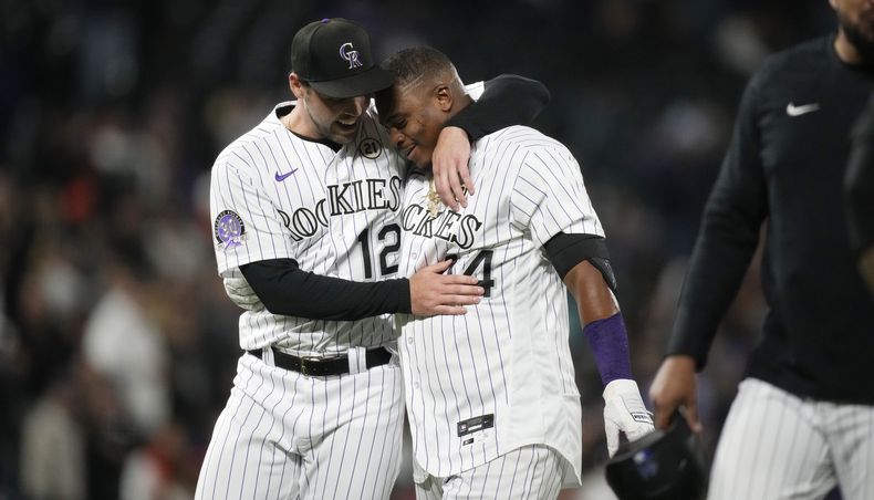 El dominicano Elehuris Montero de los Rockies de Colorado es felicitado por su compañero Sean Bouchard (izquierda) luego de su imparable para empatar el juego ante los Gigantes de San Francisco en el 9no episodio en Denver. Viernes 15 de septiembre de 2023. (AP Foto/David Zalubowski)