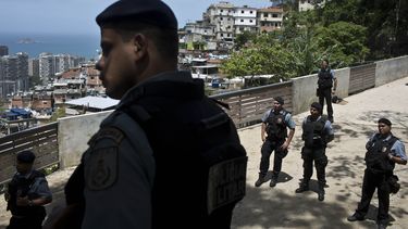 americateve | Agentes policiales observan a manifestantes que exigen saber el paradero de los restos mortales del alba&ntilde;il Amarildo de Souza, que desapareci&oacute; a mediados de junio mientras estaba custodiado por la polic&iacute;a, en R&iacute;o de Janeiro, Br