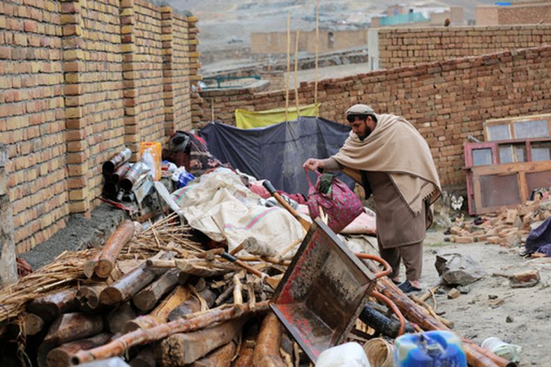 Mohibullah Niazi, vecino de la zona, busca entre los objetos apilados junto a una casa dañada por un sismo en la localidad de Ittefaq, a las afueras de Kabul, Afganistán, el 4 de abril de 2026. (AP Foto/Siddiqullah Alizai)