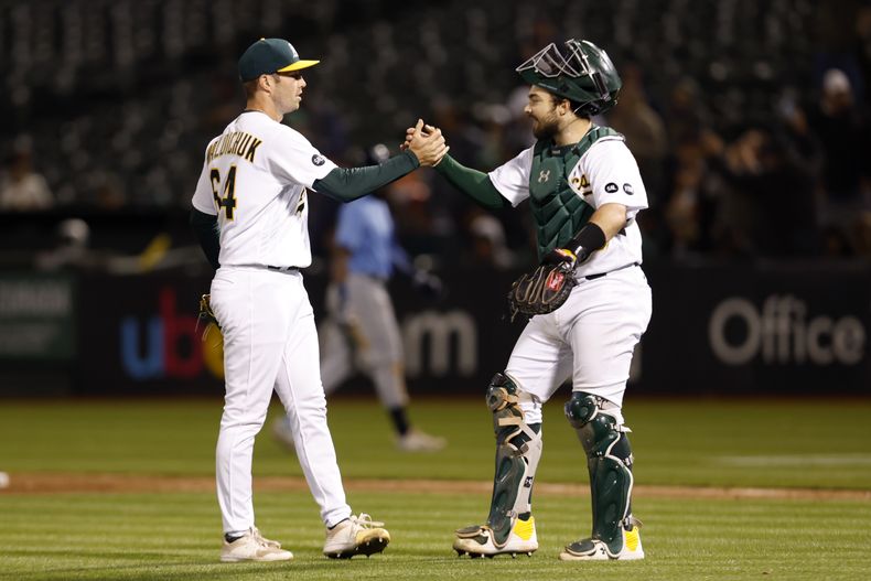 Ken Waldichuk celebra con Shea Langeliers de los Atléticos de Oakland tras superar a los Rays de Tampa Bay el lunes 12 de junio del 2023. (AP Foto/Jed Jacobsohn)