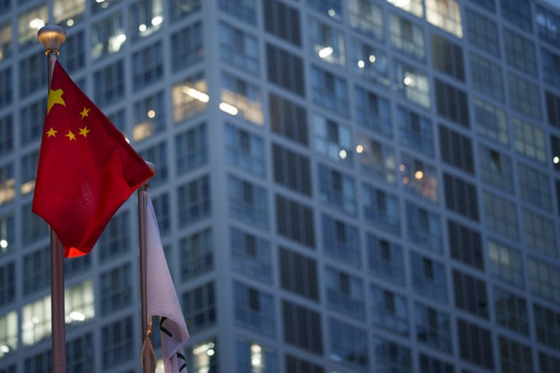 La bandera china ondea en el distrito financiero central el lunes 15 de julio de 2024, en Beijing, China. (AP Foto/Vincent Thian)