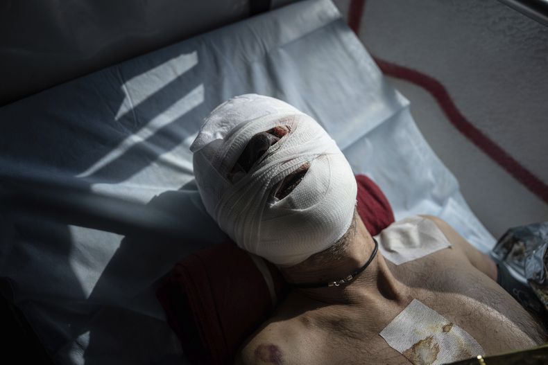 Un soldado ucraniano lesionado está acostado en una cama al interior de un autobús médico especial durante un desalojo realizado por voluntarios de la organización paramédica Hospitallers en la región de Donetsk, Ucrania, el miércoles 22 de marzo de 2023. (AP Foto/Evgeniy Maloletka)