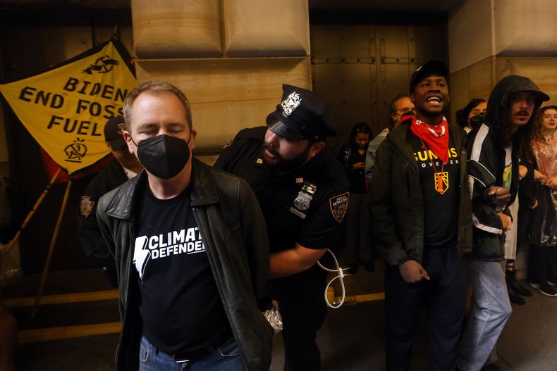 Activistas climáticos son detenidos luego de bloquear el Banco de la Reserva Federal de Nueva York para exigir el fin del uso de combustibles fósiles, el lunes 18 de septiembre de 2023, en Nueva York. (AP Foto/Jason DeCrow)