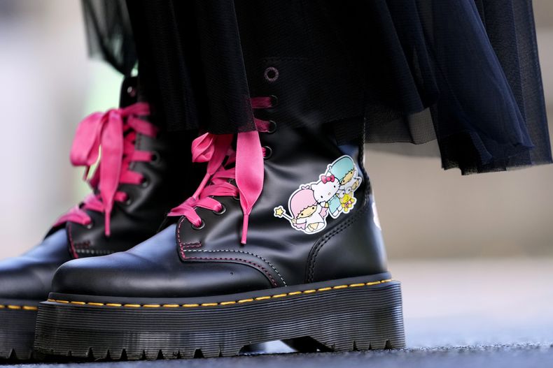 Una visitante usa botas con Hello Kitty en el Museo Nacional durante la exposición A medida que yo cambio, ella también, por el 50 aniversario de Hello Kitty en el Museo Nacional de Tokio en Tokio el miércoles 30 de octubre de 2024. (AP Photo/Shuji Kajiyama)