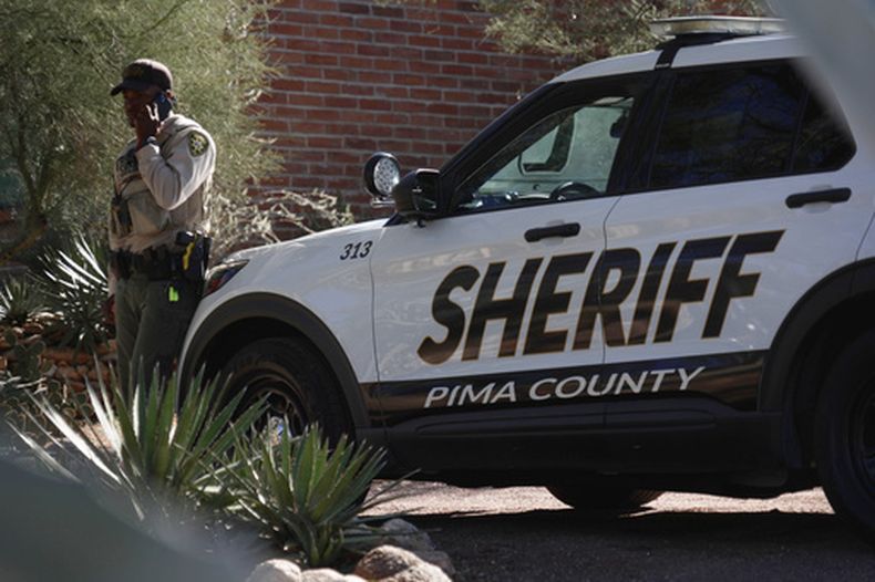 Un agente de la policía del condado Pima realiza una llamada frente a la casa de Nancy Guthrie el sábado 14 de febrero de 2026 en Tucson, Arizona. (Foto AP/Ty ONeil)
