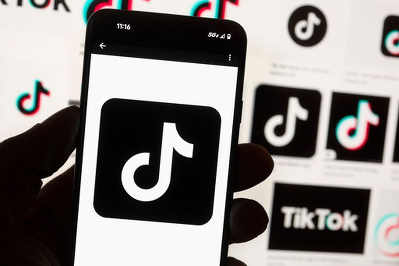 ARCHIVO - El logo de TikTok, visto en la pantalla de un celular, situado delante de la pantalla de una computadora, el 14 de octubre de 2022, en Boston. (AP Foto/Michael Dwyer, archivo)
