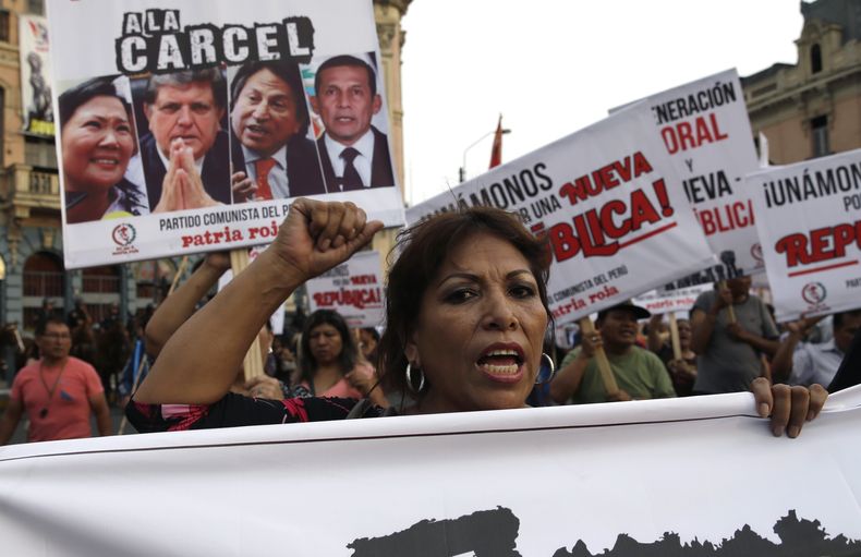 ARCHIVO - Una mujer participa en una marcha anticorrupción en la que se ve a sus espaldas un cartel con imágenes de tres expresidentes de Perú: Alan García, desde la izquierda, Alejandro Toledo y Ollanta Humala, con un mensaje de rechazo en Lima, Perú, el 16 de febrero de 2017. A un exdirectivo de la constructora brasileña Odebrecht en Perú, admitió el jueves 7 de septiembre de 2023 en juicio que la empresa entregó dinero a las campañas electorales de casi todos los presidentes peruanos que gobernaron en la última década a cambio de contratos públicos. (AP Foto/Martín Mejía, Archivo)